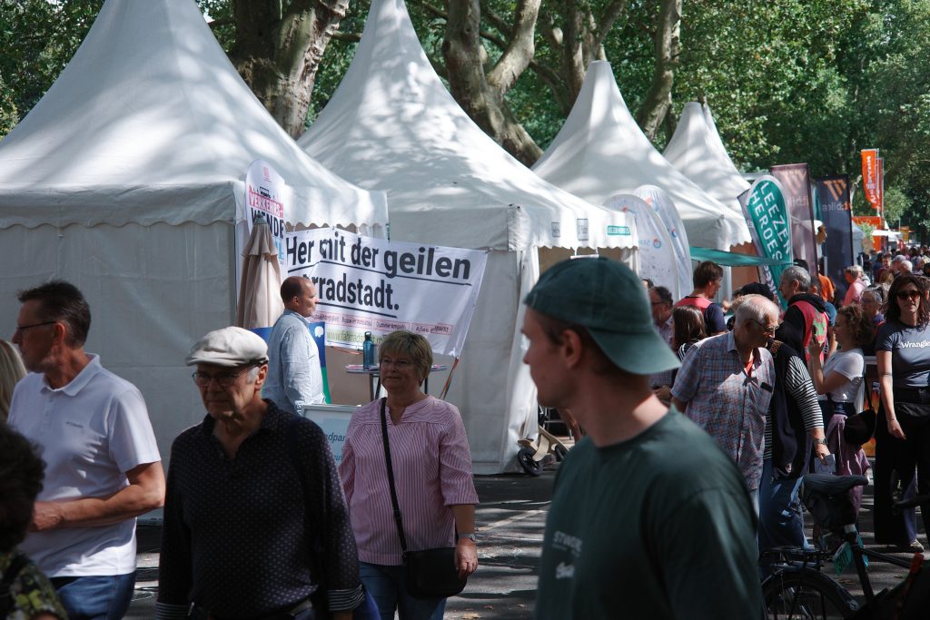 Gedränge vor einem Infostand mit einem Banner mit der Aufschrift „Her mit der geilen Fahrradstadt“.
